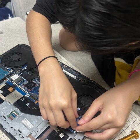 Khanduri Pakhi working on a laptop motherboard